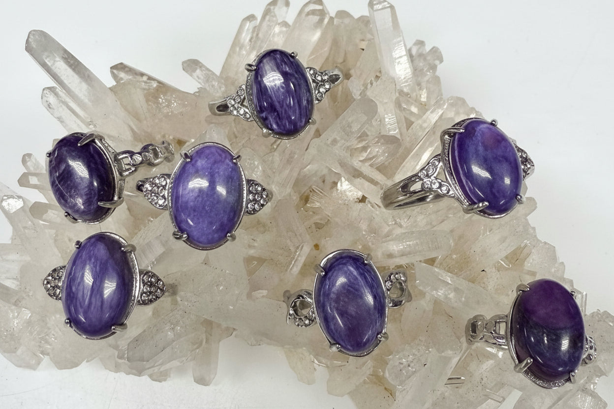 Purple gemstone rings with silver settings on a crystal background