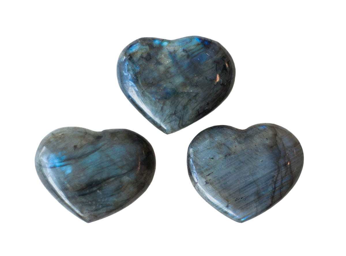 Three heart-shaped labradorite stones on a white background