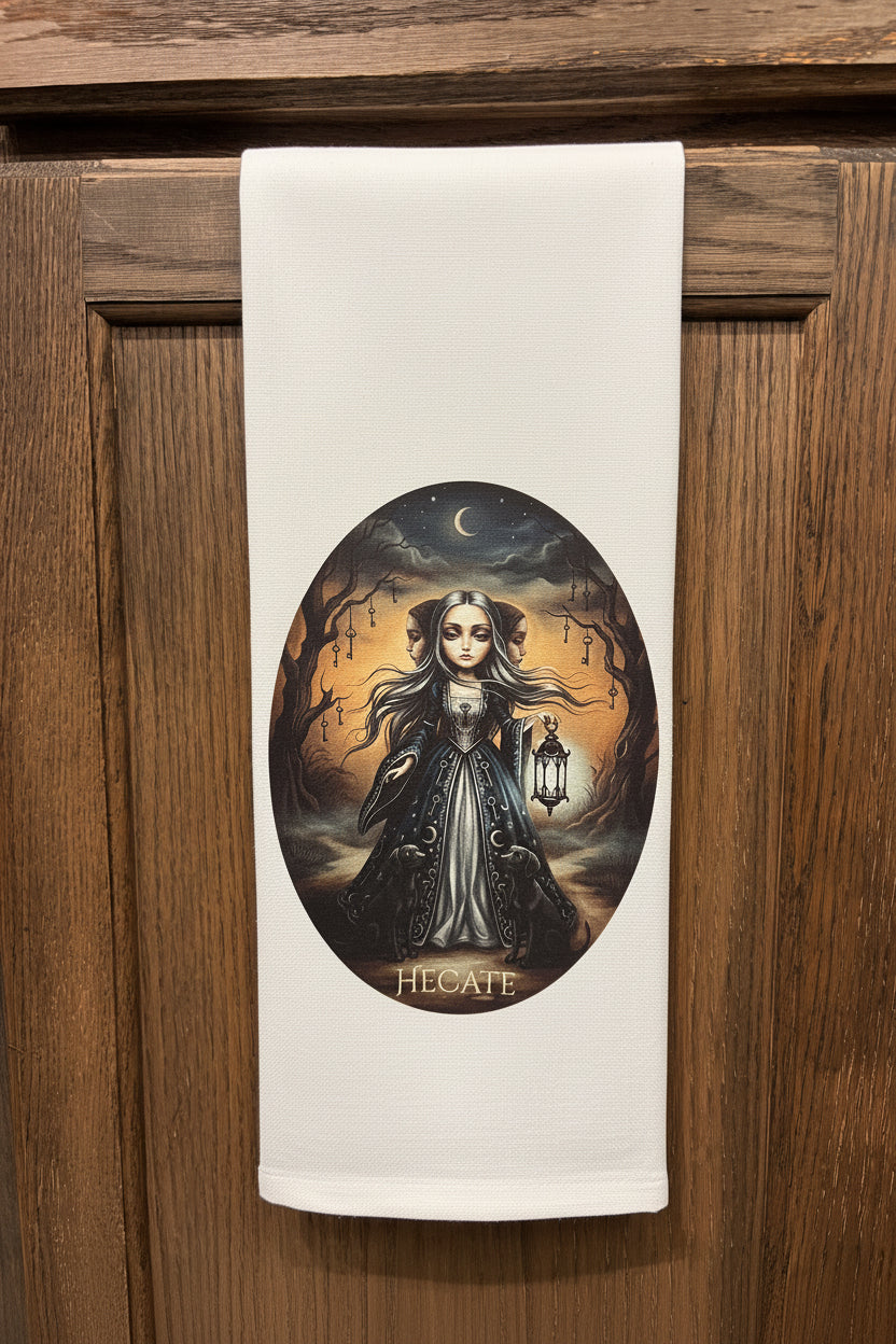 Towel with a graphic of Hecate hanging on a wooden cabinet.