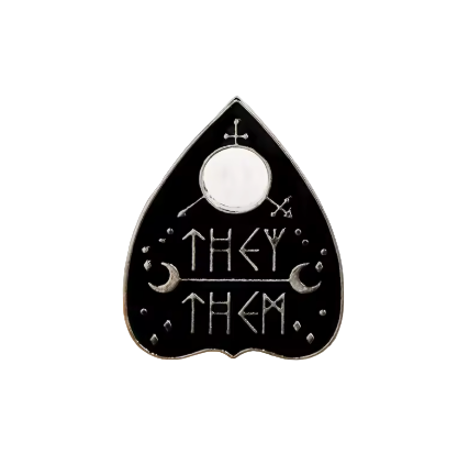 Black enamel pin with 'THEY THEM' text on a white background