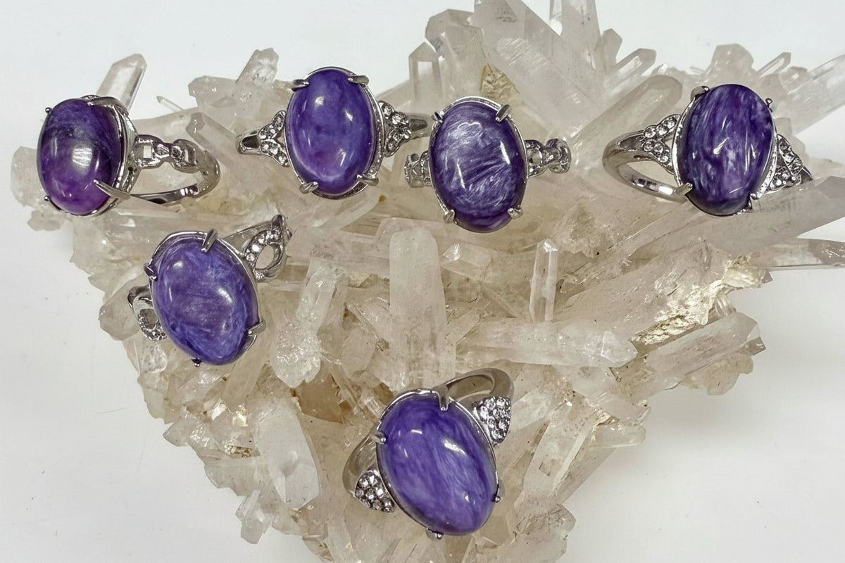 Purple gemstone rings with silver settings on a crystal background,